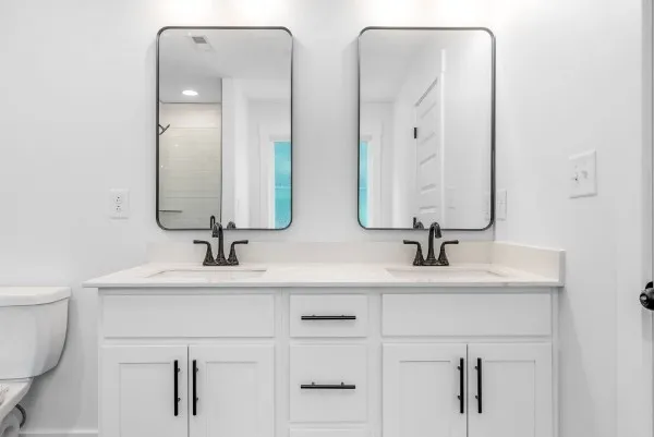 a bathroom with double vanity sinks and a mirror