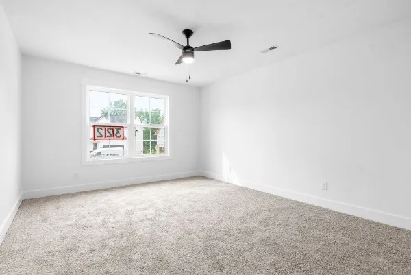 an empty room with windows and ceiling fan