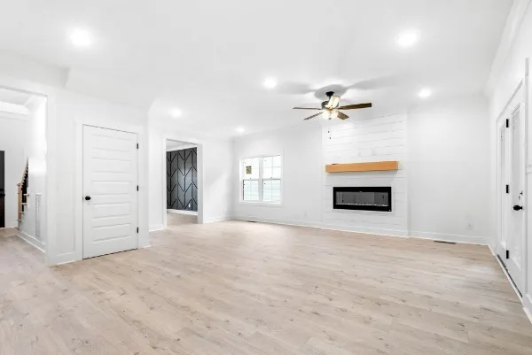 an empty room with a ceiling fan and window