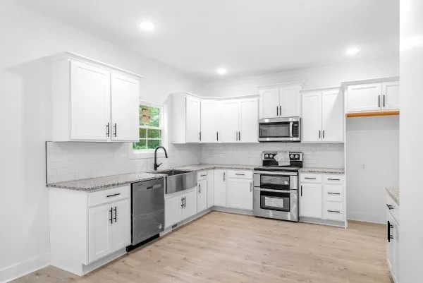 a kitchen with stainless steel appliances granite countertop a stove sink and cabinets