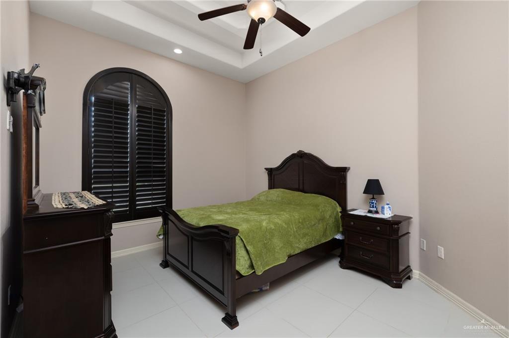 1202 Hummingbird Drive Pharr, TX 78577 - Photo 13 of 23 a bedroom with a bed and a chandelier