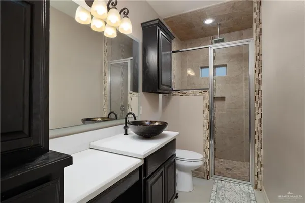 a bathroom with a double vanity sink toilet and shower