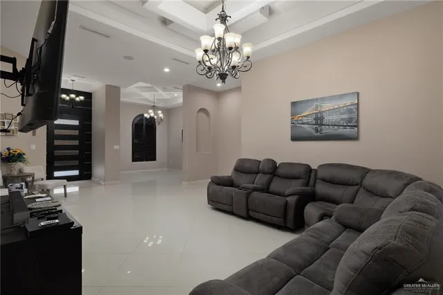 a living room with furniture a chandelier and a flat screen tv