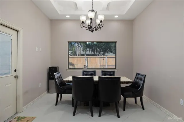 a view of a dining room with furniture a chandelier and window