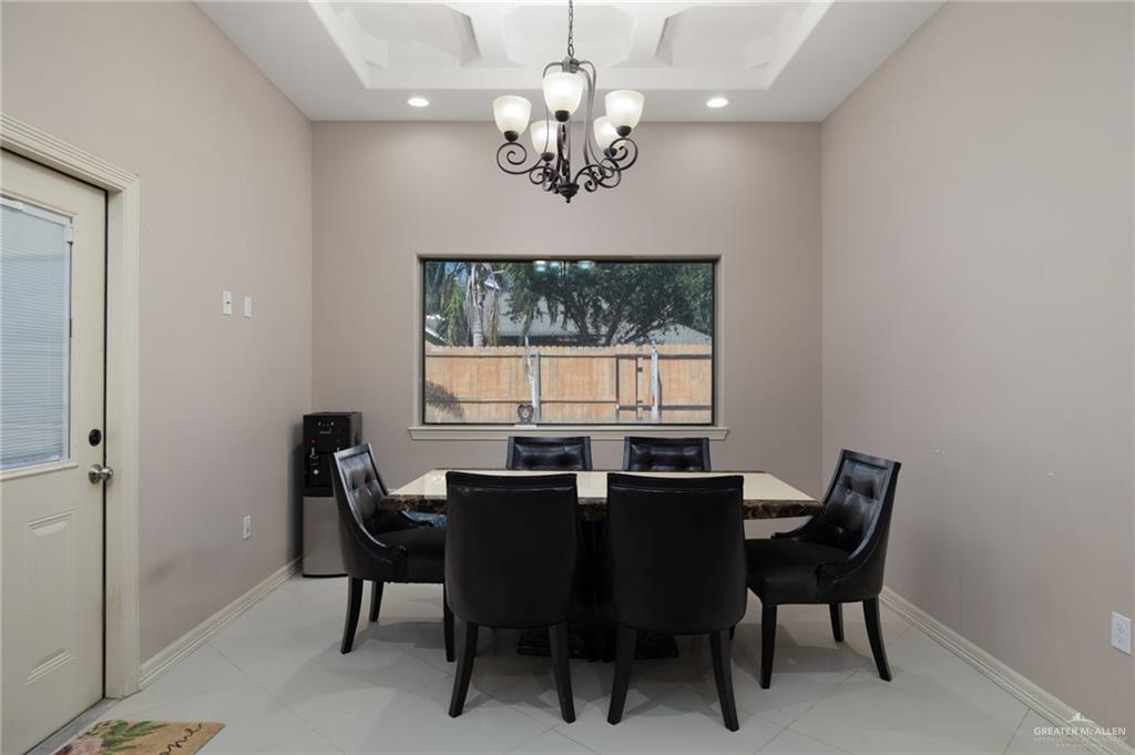 1202 Hummingbird Drive Pharr, TX 78577 - Photo 5 of 23 a view of a dining room with furniture a chandelier and window