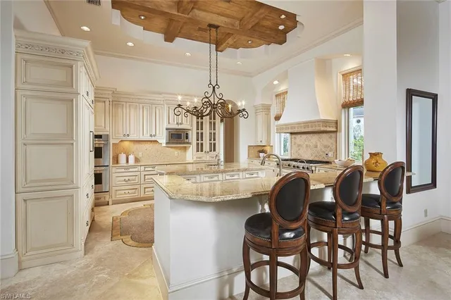 a kitchen with kitchen island granite countertop a table and chairs in it