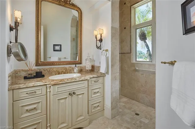 a bathroom with a granite countertop sink a mirror a vanity and a shower