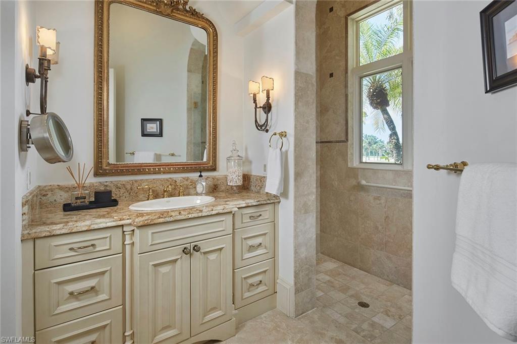 1397 Great Egret Trail Naples, FL 34105 - Photo 23 of 50 a bathroom with a granite countertop sink a mirror a vanity and a shower