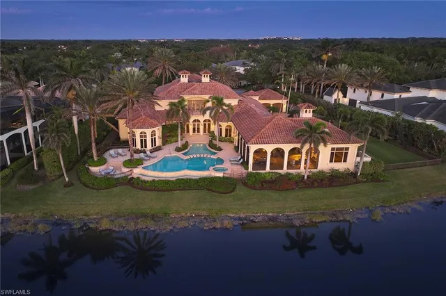 an aerial view of residential houses with outdoor space and a lake view