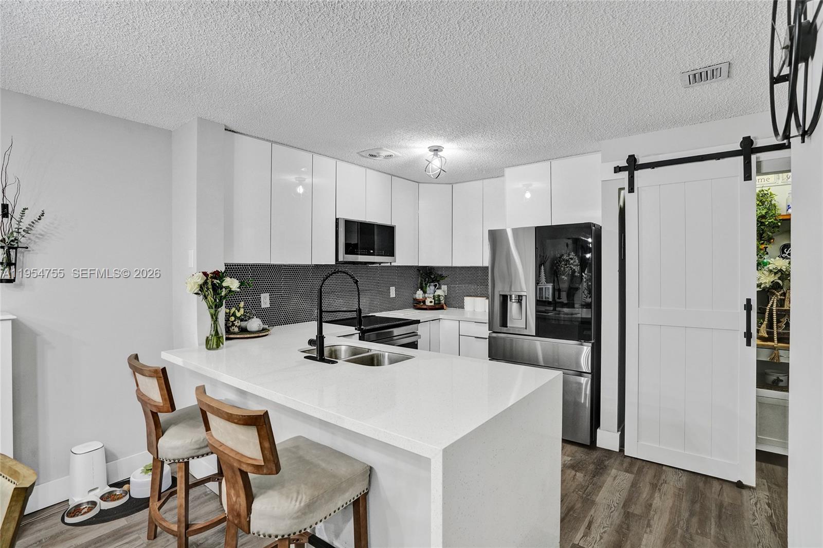 5361 Southwest 125th Avenue Miramar, FL 33027 - Photo 4 of 38 a kitchen with white cabinets and stainless steel appliances
