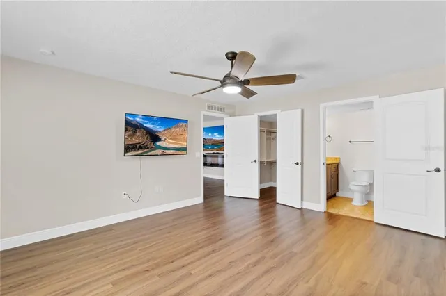 a view of a big room with wooden floor and a ceiling fan