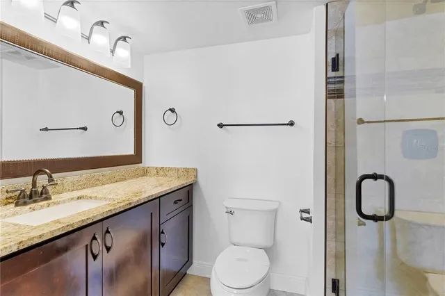 a bathroom with a granite countertop sink toilet and shower