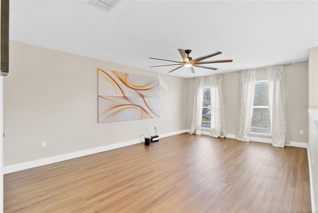 1705 Ridgemoor Drive Mascotte, FL 34753 - Photo 22 of 53 an empty room with wooden floor fan and windows