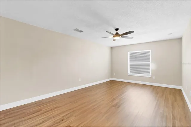 a view of room with wooden floor and ceiling fan