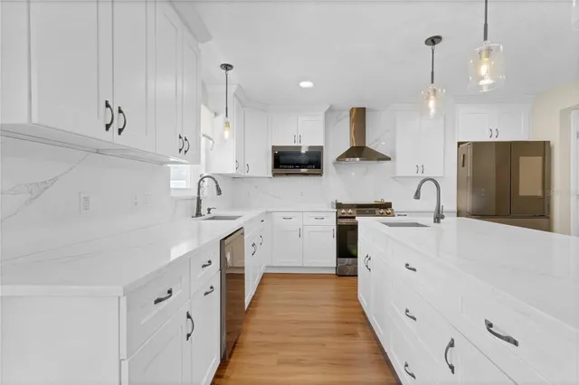a kitchen with white cabinets and stainless steel appliances