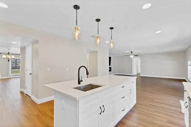 a kitchen with kitchen island a sink and wooden floor