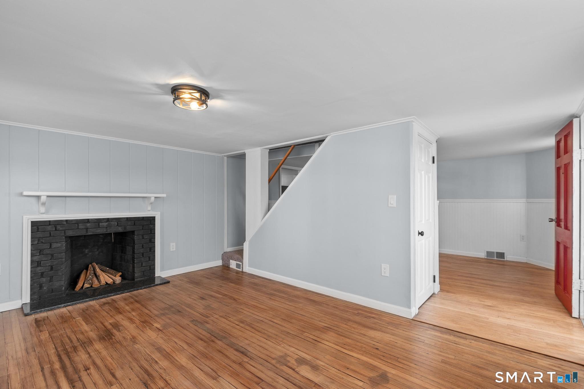 128 Machine Shop Hill Road Windham, CT 06266 - Photo 6 of 45 a view of a livingroom with wooden floor and a fireplace