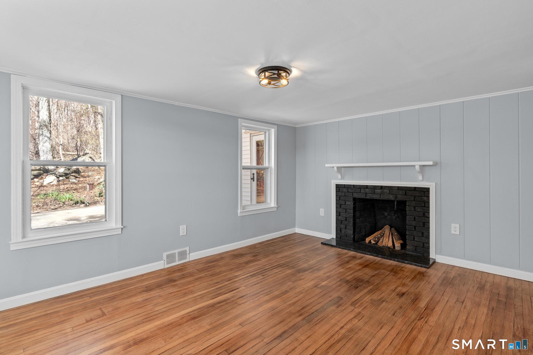 128 Machine Shop Hill Road Windham, CT 06266 - Photo 7 of 45 a view of an empty room with wooden floor fireplace and a window