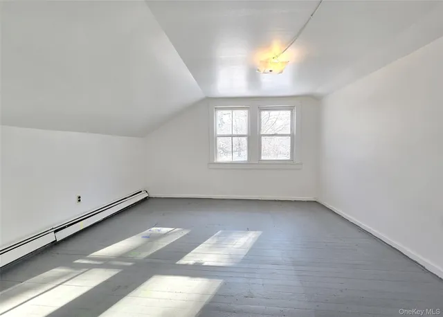 an empty room with a window and mirror