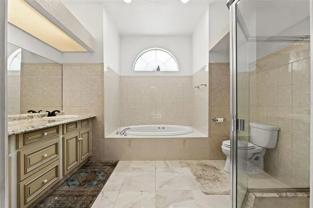 a spacious bathroom with a double vanity sink a toilet and a mirror