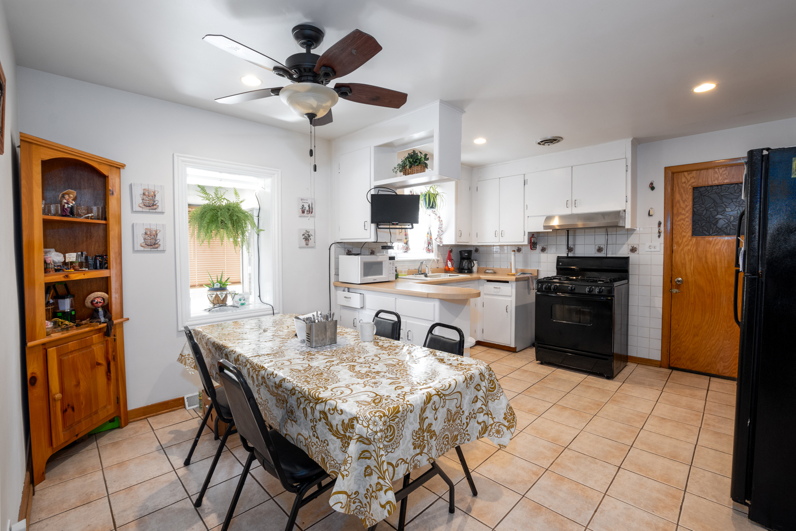 5328 South Harding Avenue Chicago, IL 60632 - Photo 9 of 26 a kitchen with stainless steel appliances kitchen island granite countertop a refrigerator a stove a sink a dining table and chairs with wooden floor