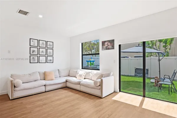 a living room with furniture and a floor to ceiling window