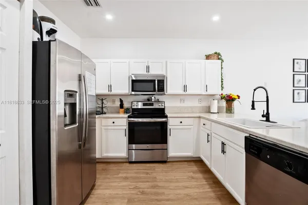 a kitchen with a sink stainless steel appliances and cabinets
