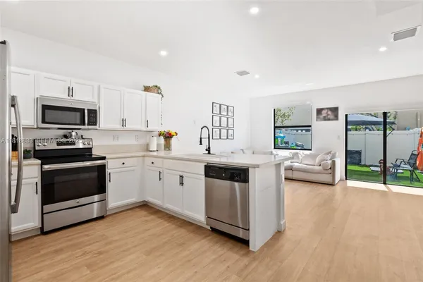 a kitchen with sink cabinets and stainless steel appliances