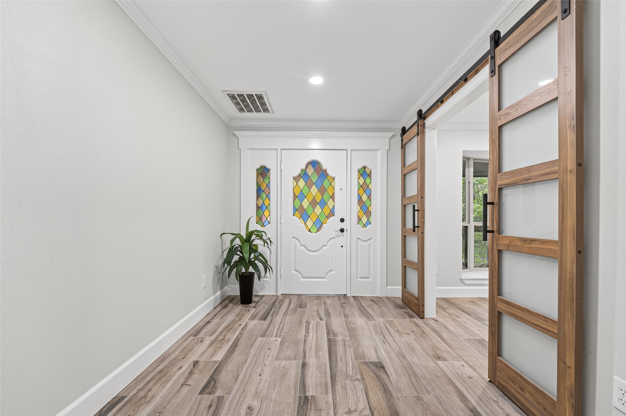 23607 Cardinal Drive Hockley, TX 77447 - Photo 5 of 50 The foyer sets a sophisticated tone, where ceramic wood-look tiling meets rustic barn doors that slide open to reveal a versatile greeting space.