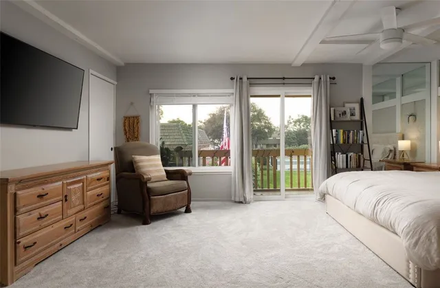 a living room with furniture a flat screen tv and a large window