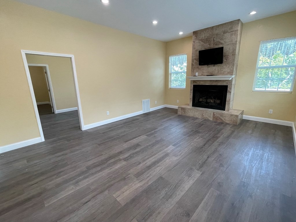 1763 Rays Gap Road Seymour, TN 37865 - Photo 17 of 34 an empty room with wooden floor and fireplace