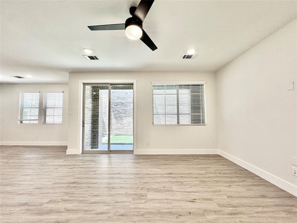 8749 Scotty's Lk Lane The Colony, TX 75056 - Photo 11 of 33 Spare room with light wood-style floors, baseboards, and ceiling fan
