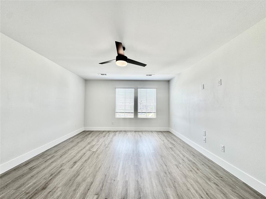 8749 Scotty's Lk Lane The Colony, TX 75056 - Photo 17 of 33 Empty room featuring wood finished floors, a ceiling fan, and baseboards