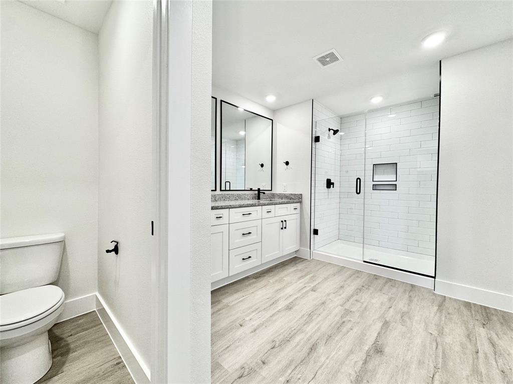 8749 Scotty's Lk Lane The Colony, TX 75056 - Photo 19 of 33 Full bath featuring toilet, wood finished floors, a stall shower, baseboards, and vanity