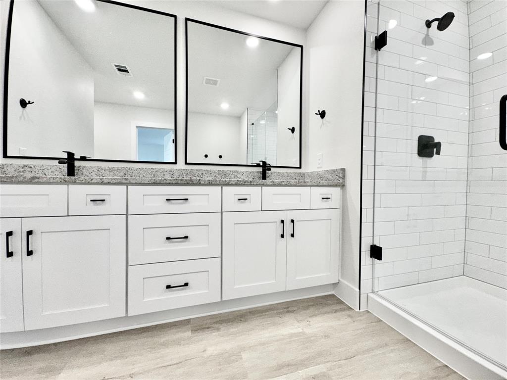 8749 Scotty's Lk Lane The Colony, TX 75056 - Photo 21 of 33 Bathroom featuring wood finished floors, a stall shower, double vanity, and recessed lighting