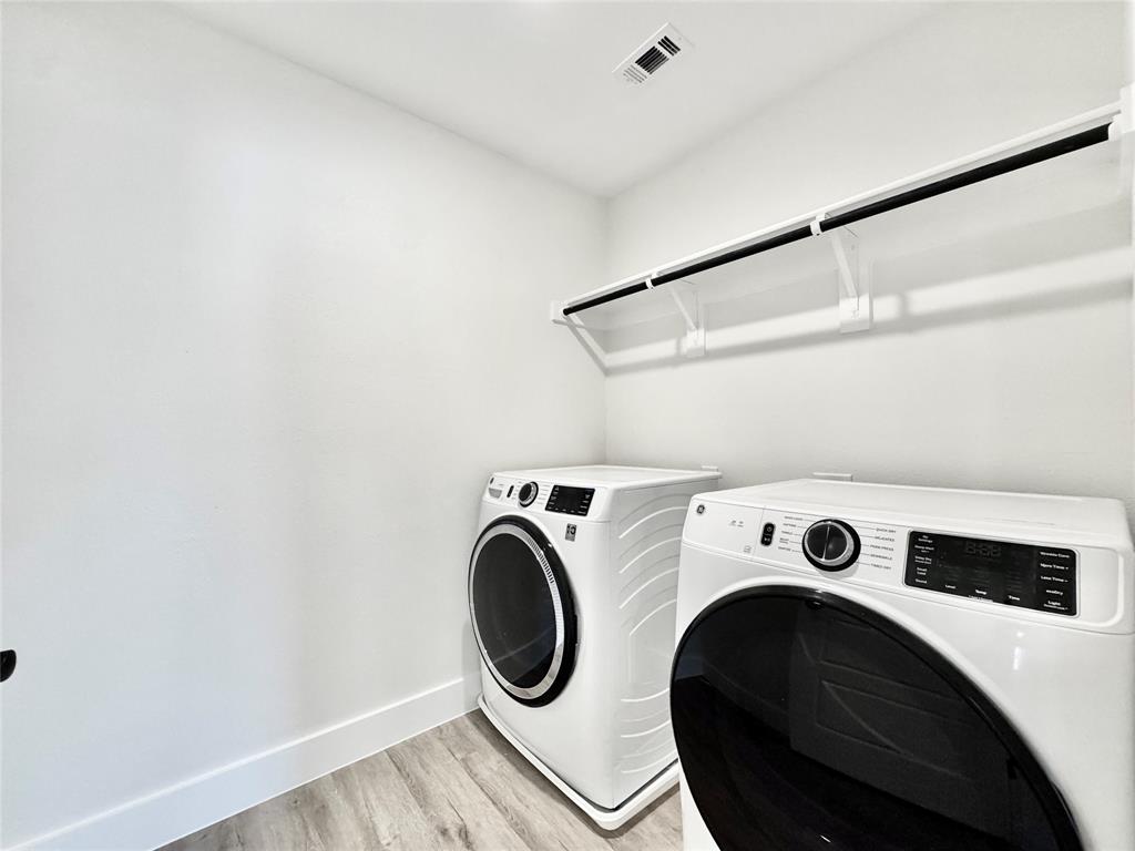8749 Scotty's Lk Lane The Colony, TX 75056 - Photo 23 of 33 Laundry room featuring washer and clothes dryer, light wood-style flooring, and baseboards