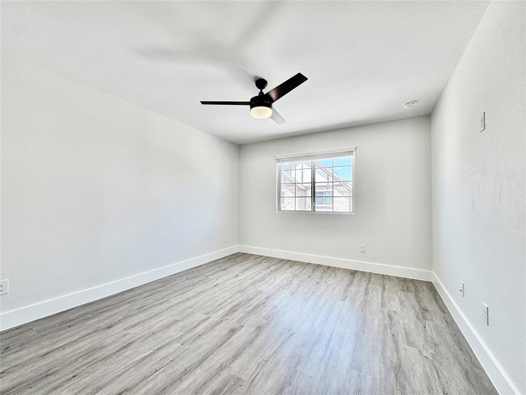 8749 Scotty's Lk Lane The Colony, TX 75056 - Photo 25 of 33 Spare room featuring wood finished floors, baseboards, and a ceiling fan