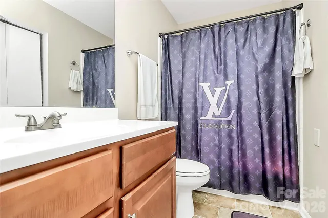 a bathroom with a sink a toilet and a shower curtain