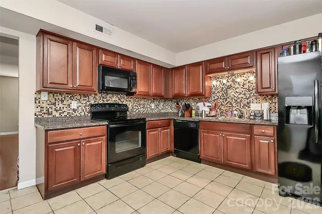 a kitchen with stainless steel appliances granite countertop a stove sink and cabinets