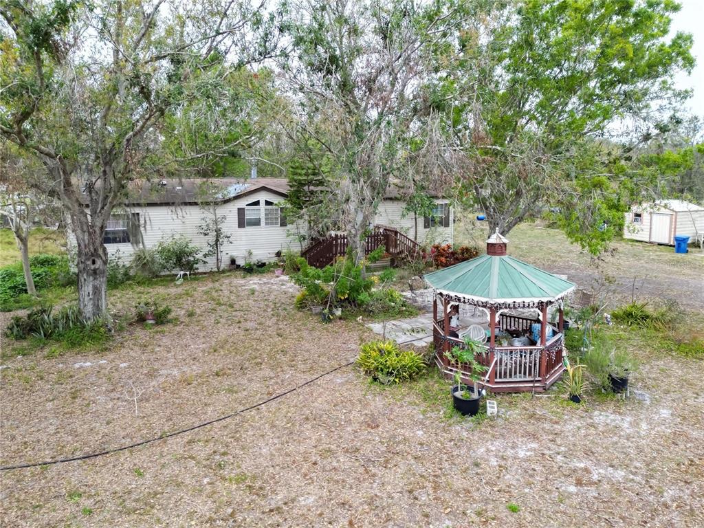 17273 Alderman Turner Road Wimauma, FL 33598 - Photo 21 of 60 a wooden bench sitting in middle of a yard