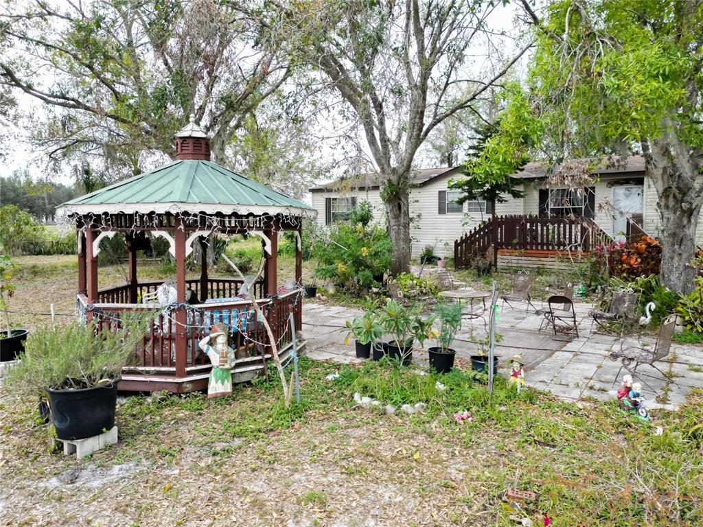 17273 Alderman Turner Road Wimauma, FL 33598 - Photo 46 of 60 a view of a chairs and table in backyard