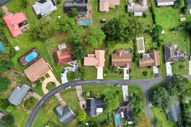 an aerial view of residential houses with outdoor space and trees