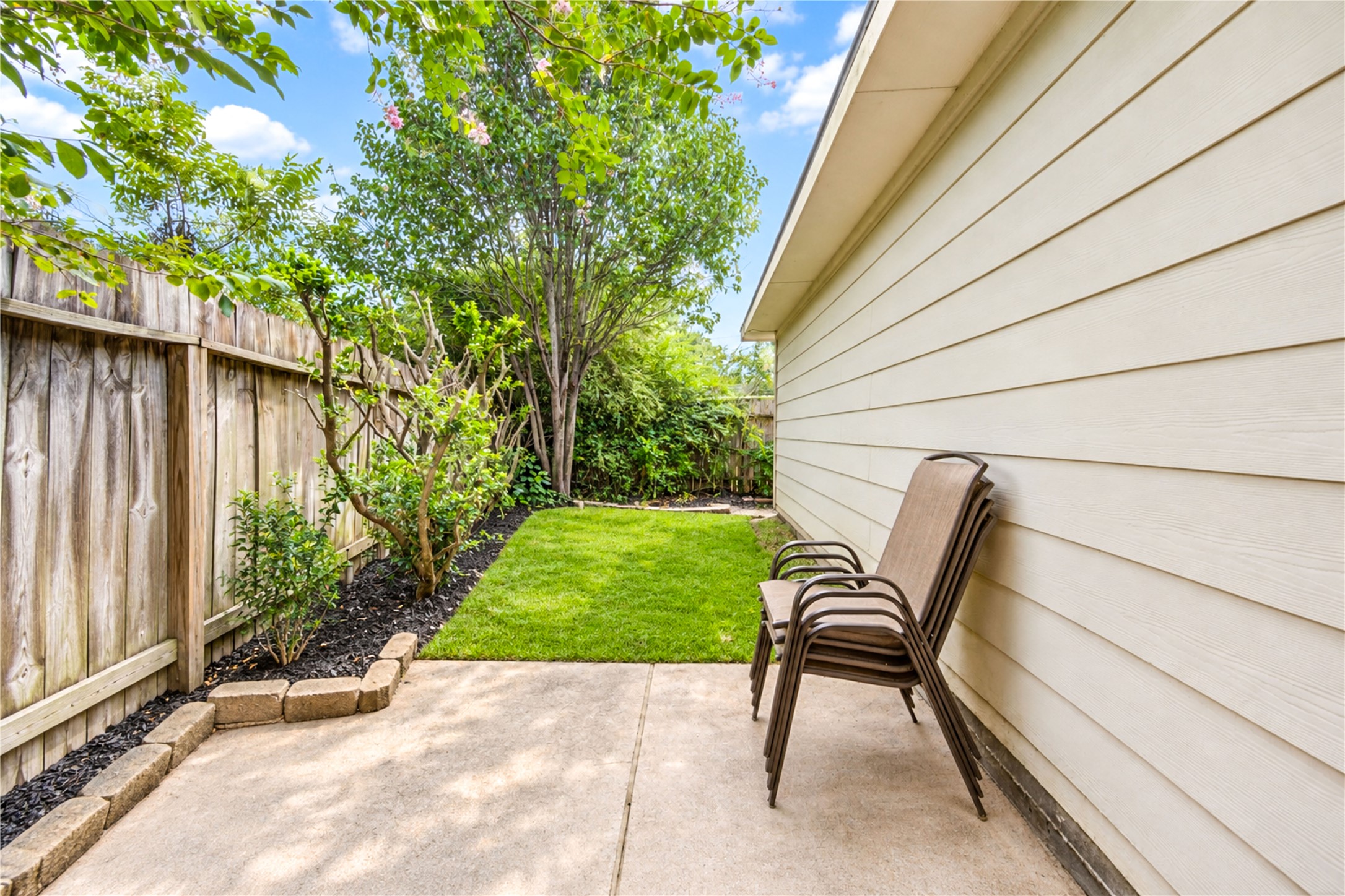 12806 Ridge Bank Lane Houston, TX 77041 - Photo 37 of 44 Charming backyard space featuring a neatly manicured lawn and a cozy patio area, perfect for relaxation and outdoor gatherings.