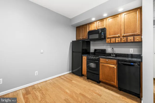 a view of kitchen with refrigerator and wooden floor