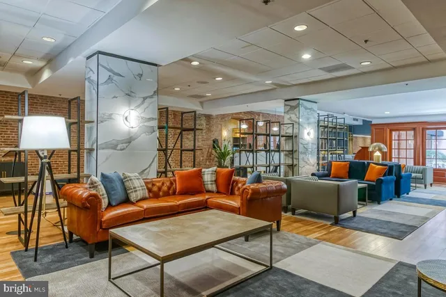 a living room with furniture a lamp and a table