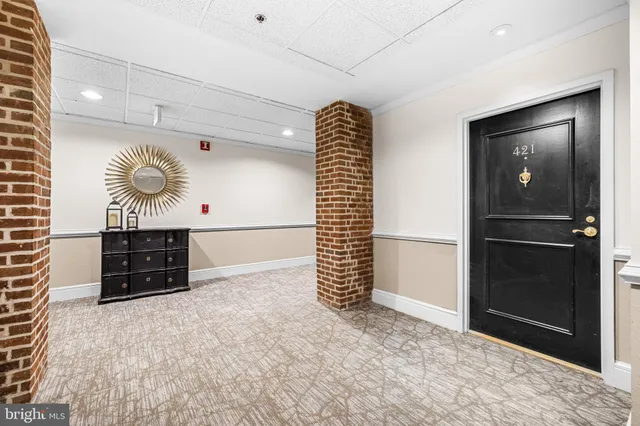 a view of kitchen with cabinets and refrigerator