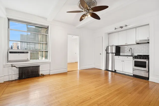 a view of a kitchen with stainless steel appliances wooden floor and a window