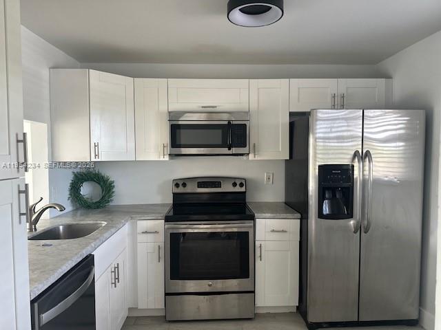 3905 North Nob Hill Road, Unit 304 Sunrise, FL 33351 - Photo 3 of 17 a kitchen with stainless steel appliances a stove a sink and a microwave