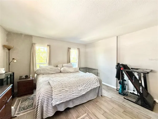 a bedroom with a bed and a view of living room