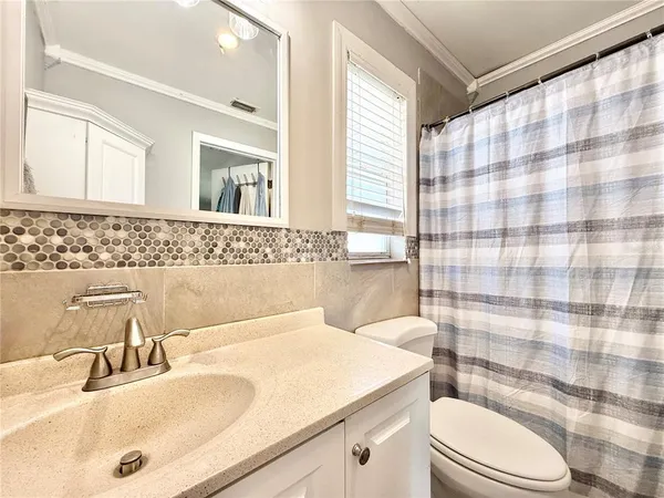 a bathroom with a sink a toilet and shower curtain